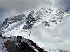 35 Broad Peak Central And Main Summits From Baltoro Glacier Between Goro II and Concordia Broad Peak (8047m) came into view before reaching Concordia. The Central Summit is on the left and the Main summit is on the far right. Its name was originally set as K3, right after the famed K2. But when Sir Martin Conway saw the peak in close detail, with its summit over a mile long, he named it �Broad Peak� which has stuck to this day. The first ascent of Broad Peak was completed by Marcus Schmuck, Fritz Wintersteller, Kurt Diemberger, and Hermann Buhl on June 9, 1957. This extremely small expedition marked a major step forward in the development of Himalayan climbing. Diemberger: �[Buhl's] plan was that from base camp onwards there would only be climbers on the mountain; they would do everything, load-carrying, establishment of camps and, finally, the assault on the summit. And it was all to be done without the use of oxygen.� Diemberger reached the summit just as Marcus Schmuck and Fritz Wintersteller started their descent. As Diemberger was descending from the summit he met Buhl still ascending. �Slowly, with all that incredible strength of his will, he started to move, very slowly, upwards. ... Two men were standing on a peak, still breathing heavily from the ascent, their limbs weary - but they did not notice it; for the all-enveloping glory of the sun's low light had encompassed them too. Deeper and deeper grew the colours. ... No dream-picture, this. It was real enough, and it happened on the 26,404-foot summit of Broad Peak.� � Summits And Secrets by Kurt Diemberger.